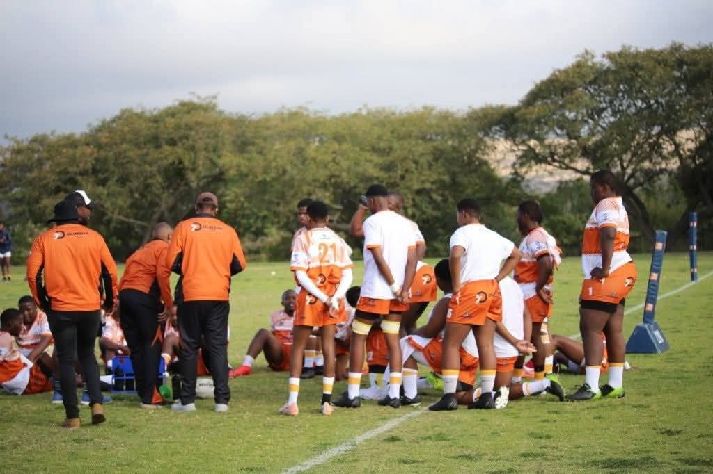 Olutsha Academy players and coaches gathered on the touchline